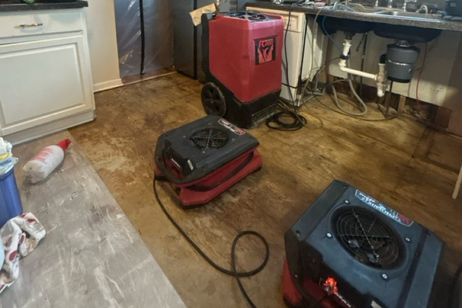 Air movers and dehumidifier arranged on a kitchen floor